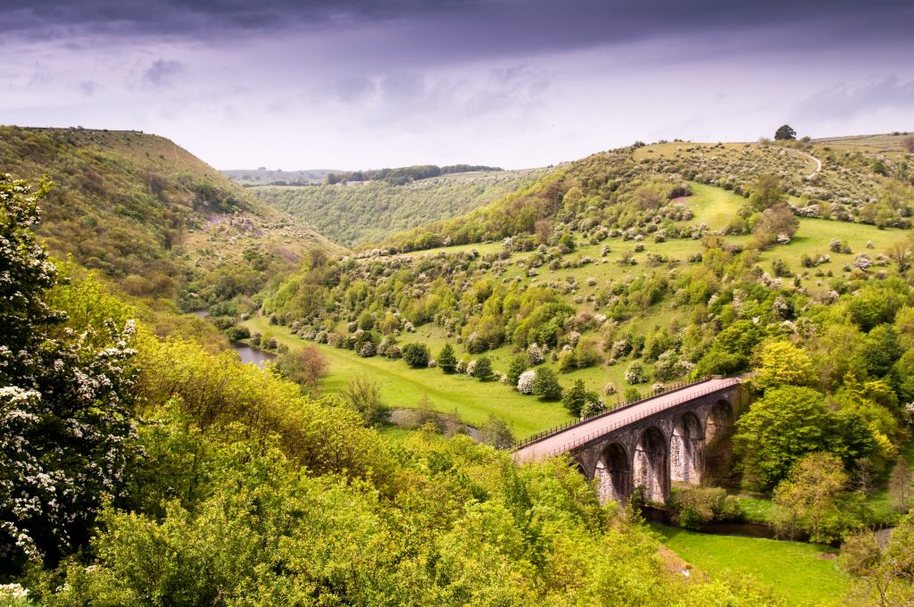 Bridge over green valley in Peak District